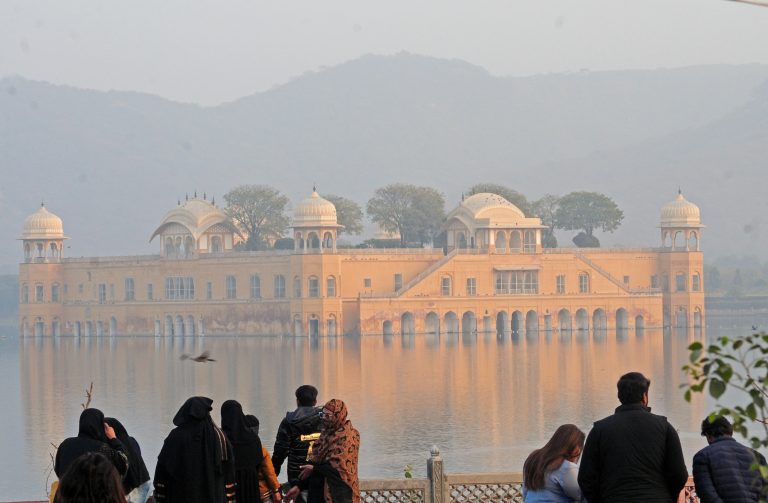 Tourists visit the Jal Mahal on a cold winter day